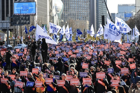 epa11033536 Doctors hold a rally calling on the government to retract its plan to expand the medical school quota, in central Seoul, South Korea, 17 December 2023. The Korean Medical Association (KMA) ...