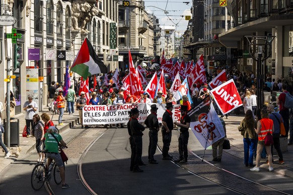 KEYPIX - Des manifestants avec des pancartes et des drapeaux defilent dans les rues de Geneve, lors du defile du 1er mai - Fete du Travail, ce jeudi 1 mai 2025 a Geneve. Le traditionnel cortege du 1er ...