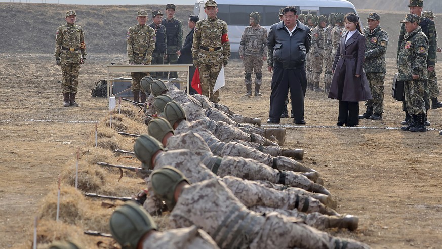 In this photo provided by the North Korean government, North Korean leader Kim Jong Un, standing in front center, and his daughter inspect a training of the Korean People&#039;s Army airborne units in ...